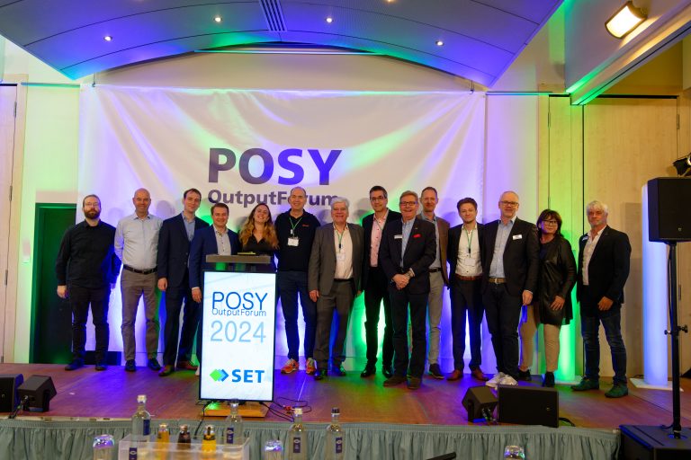 Gruppe von Personen, die beim POSY OutputForum 2024 auf einer Bühne posieren.