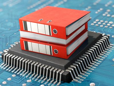 Zwei rote Aktenordner auf einem Mikrochip mit elektronischen Schaltkreisen im Hintergrund.